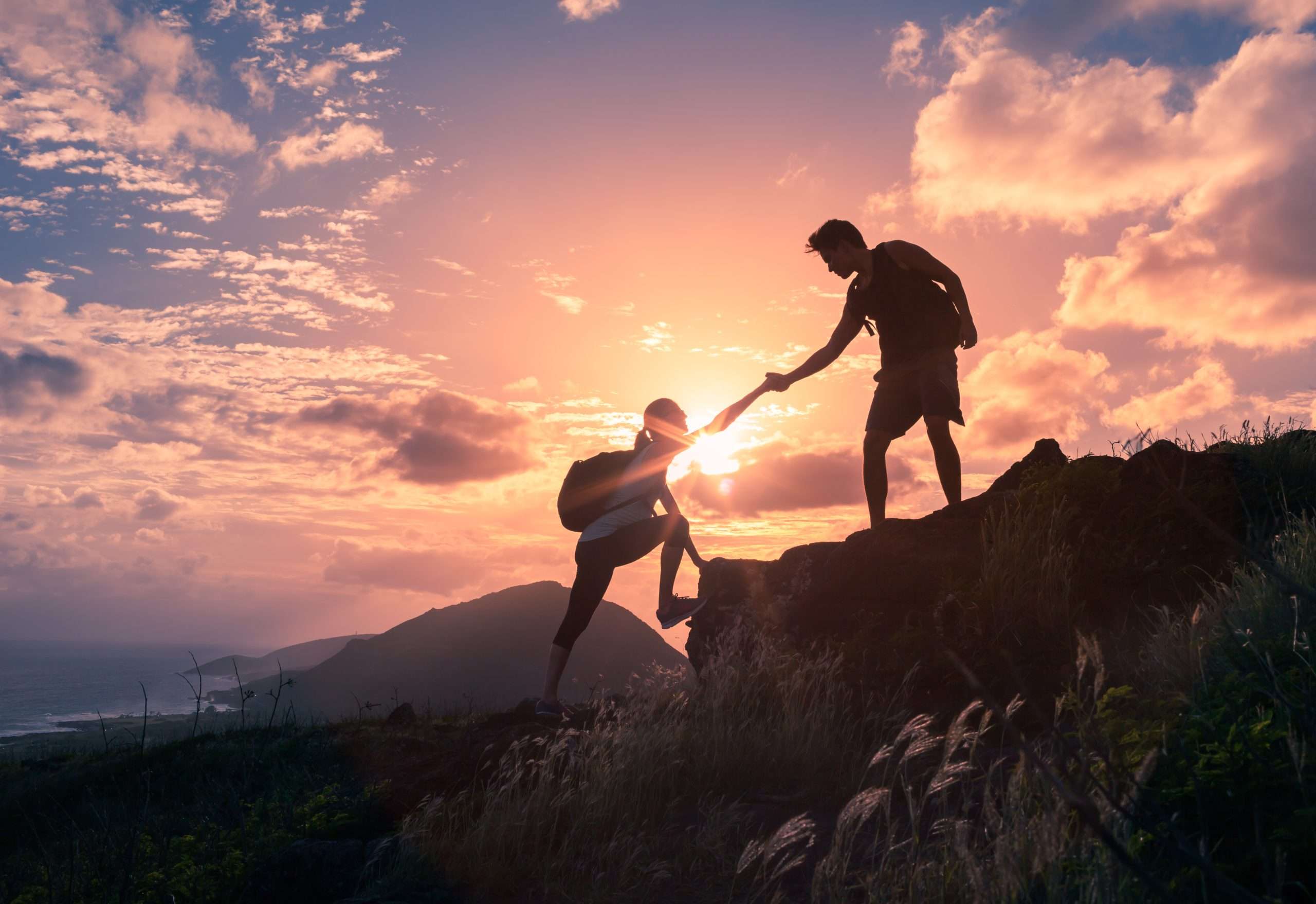 People helping each other on a hike
